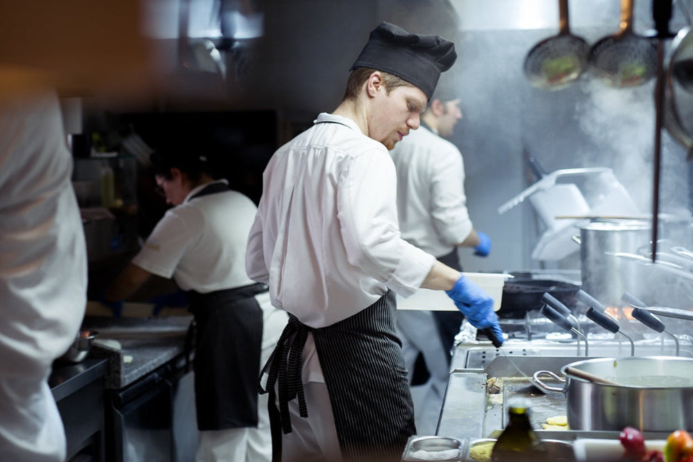 Chef in chefwear uniform working in a kitchen