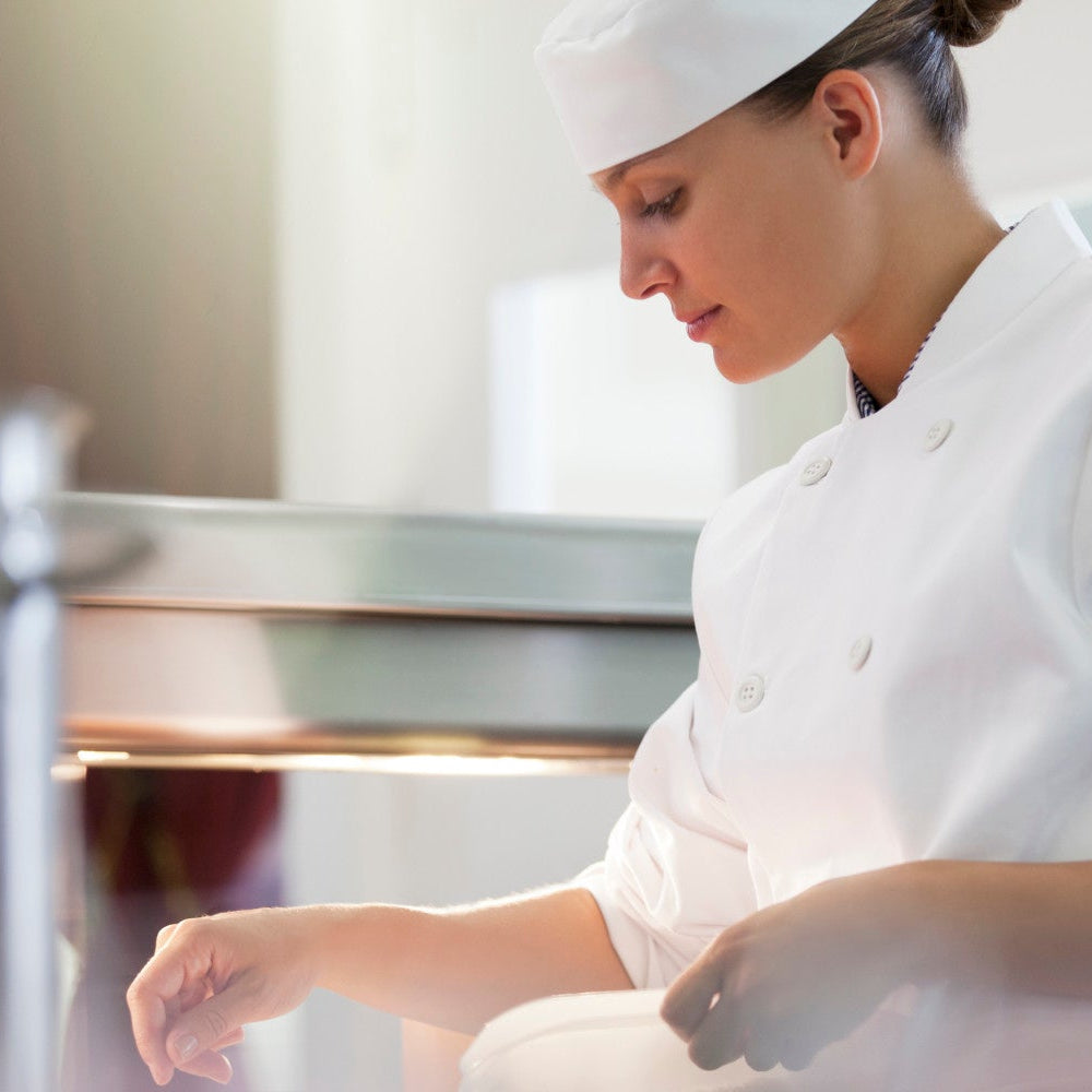 Person in a chef's uniform working in a kitchen