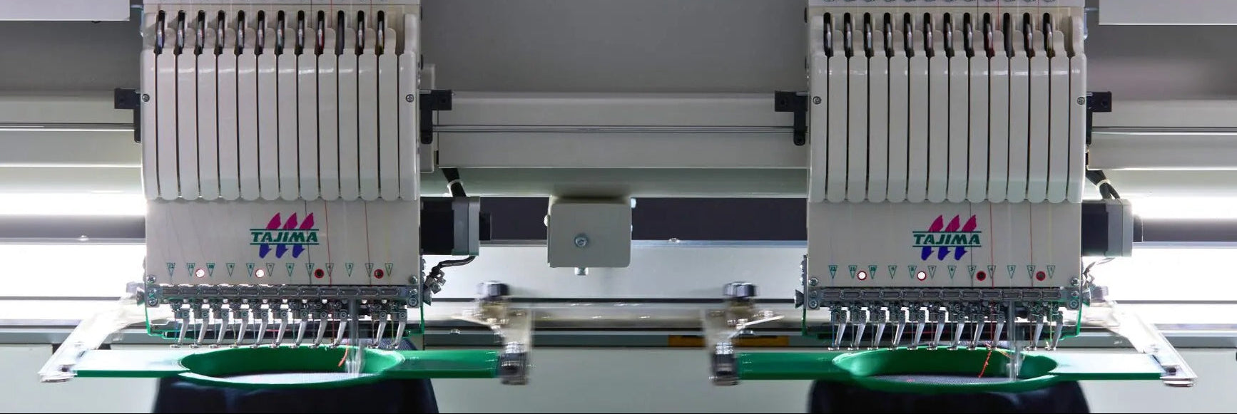 Tajima TMEZ embroidery machines on a gray background